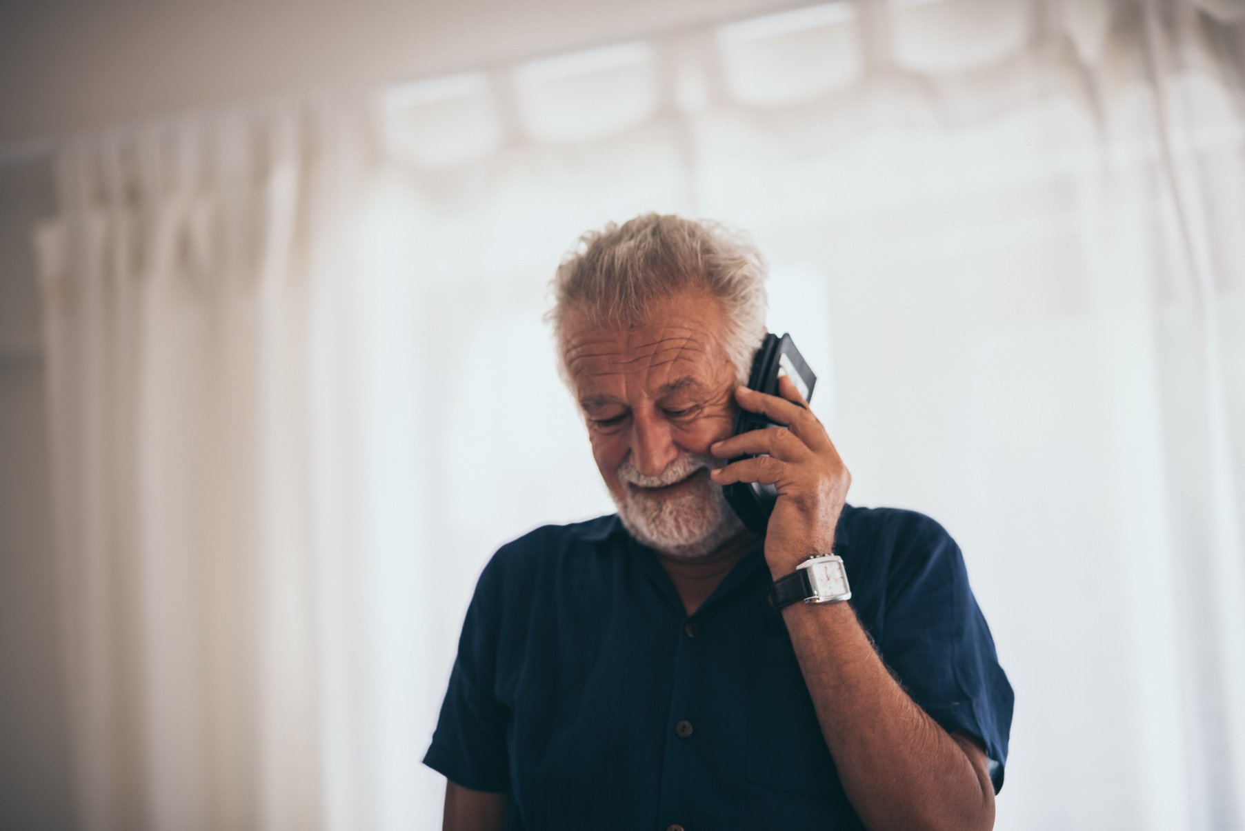 Grandpa Is Talking on the Phone Happily in the House.