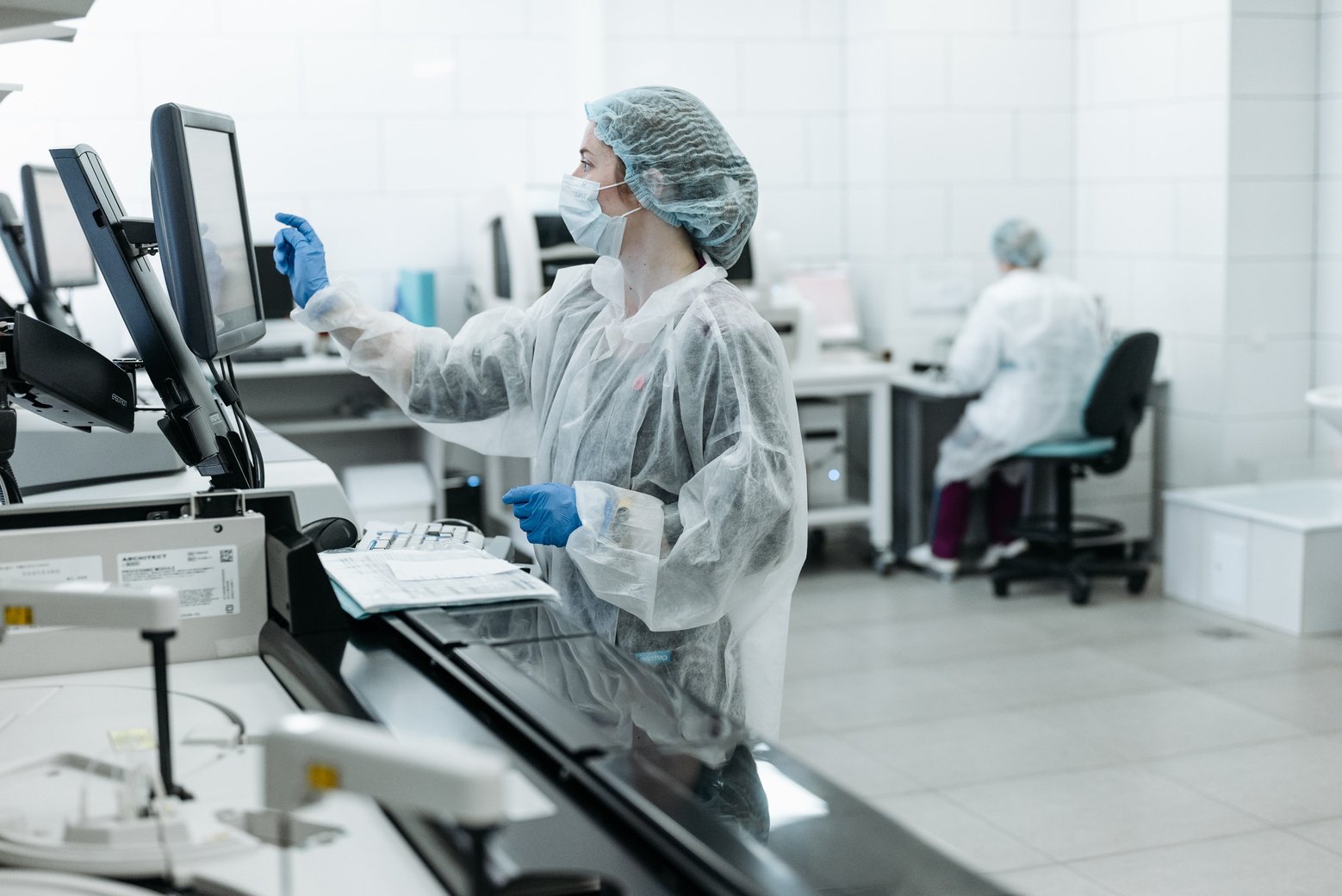 Woman in White Protective Suit Using Computer